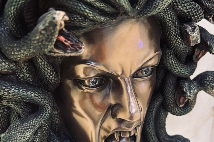Bronze Medusa sculpture with snake hair, open mouth, fierce expression.