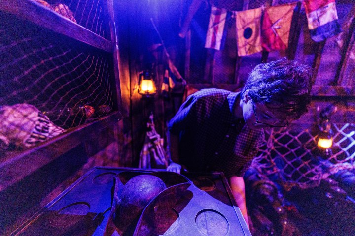 Person in dimly lit room with nautical decor and purple lighting.