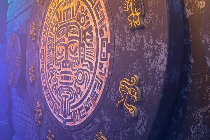 Colorful stone wall with ancient symbols and ornate circular design.