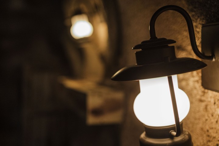 Warmly lit wall-mounted lantern with a blurred background.